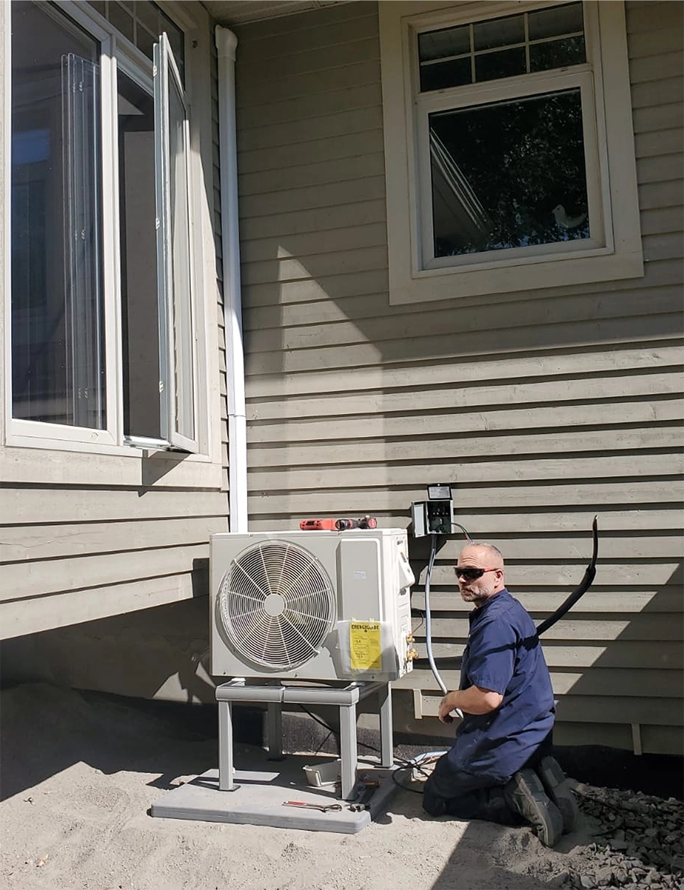 Tech installing a mini split outdoors unit