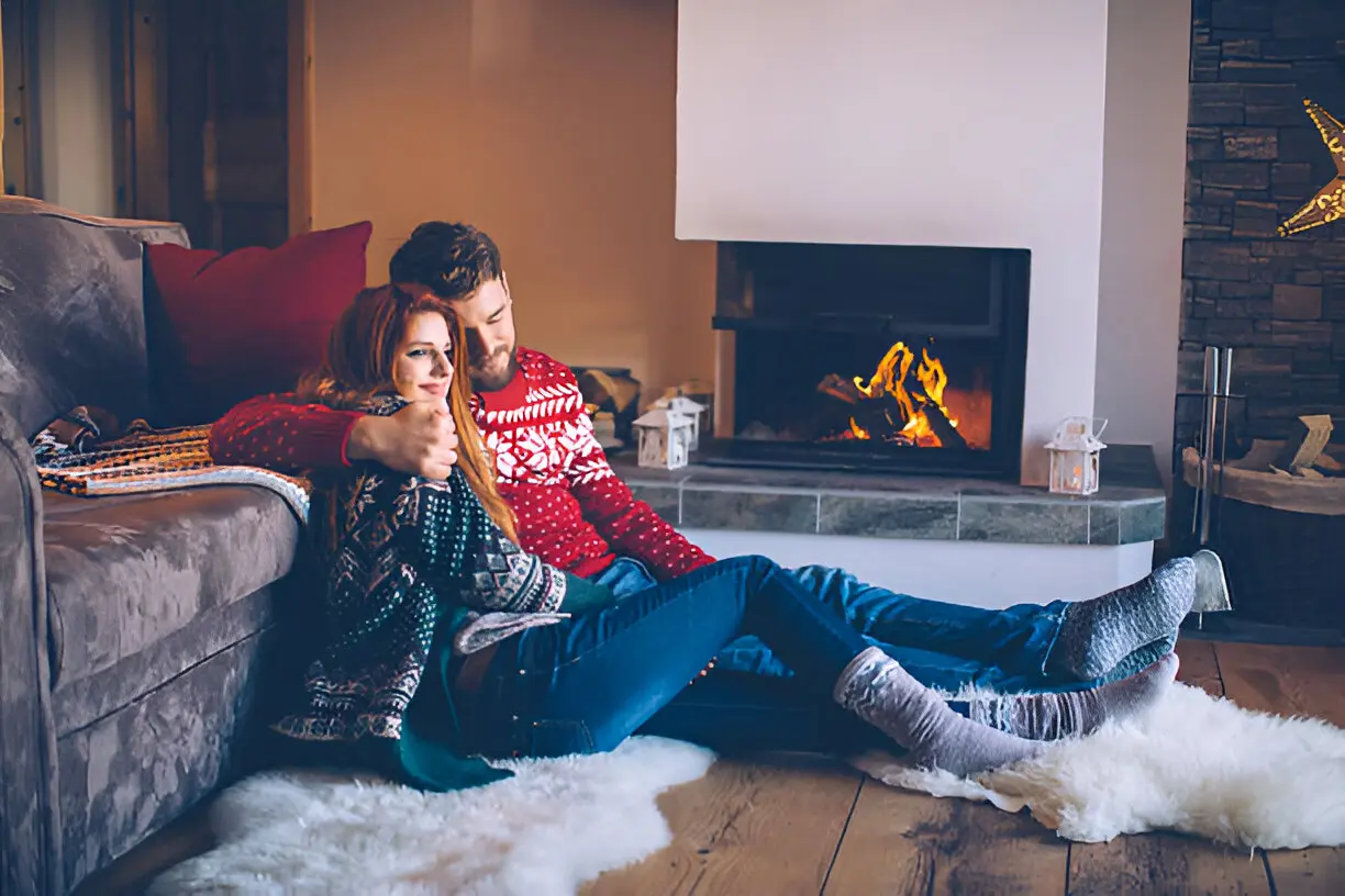 Logs fireplace and happy couple